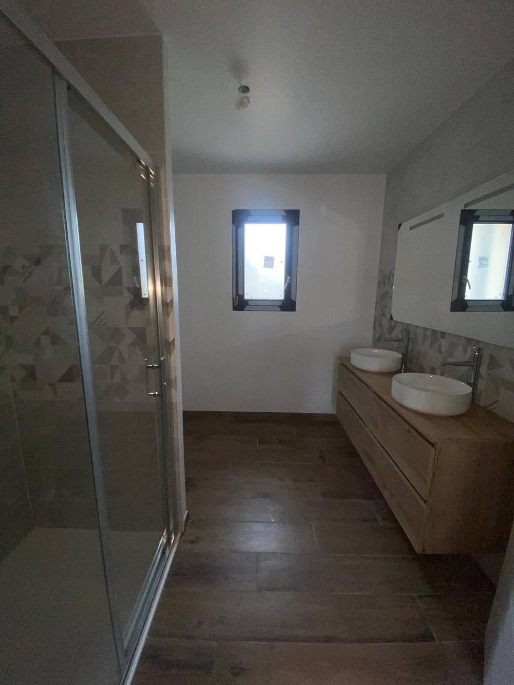 Salle de bain avec double vasque, meuble bois et douche