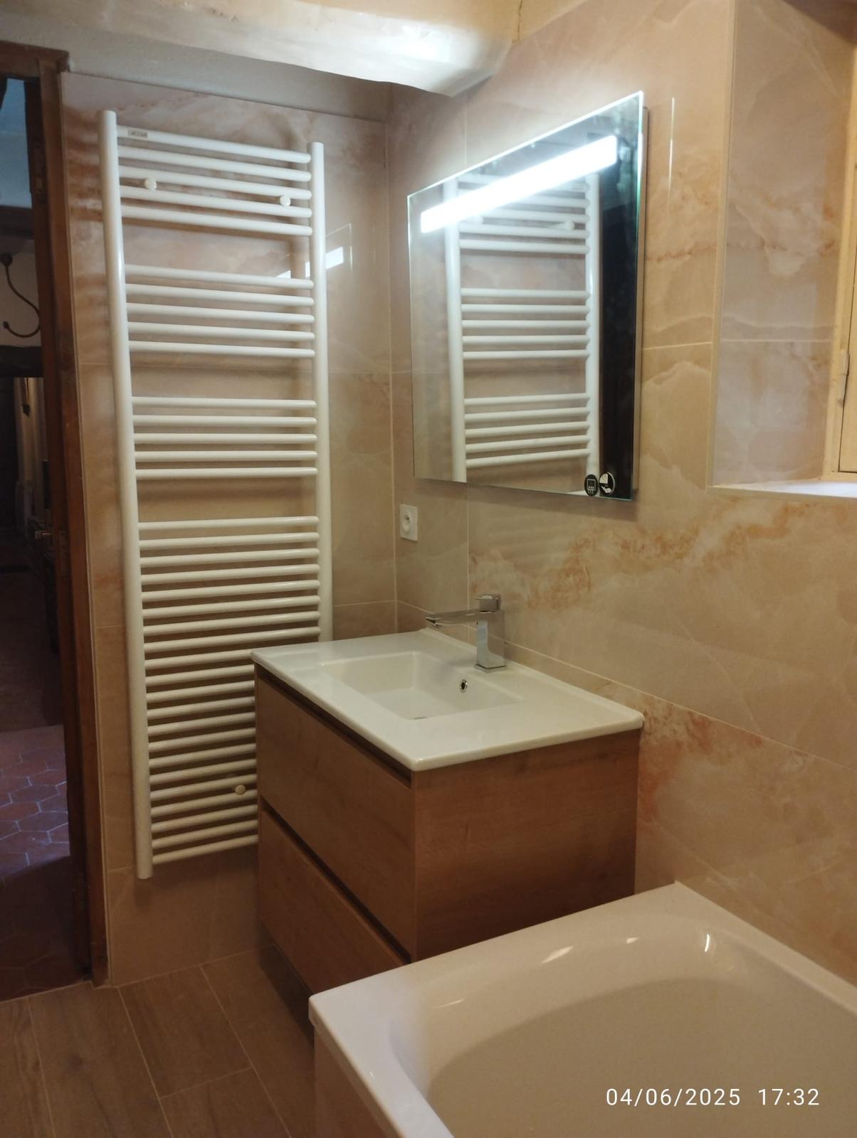 Salle de bain rénovée avec meuble vasque et sèche-serviettes