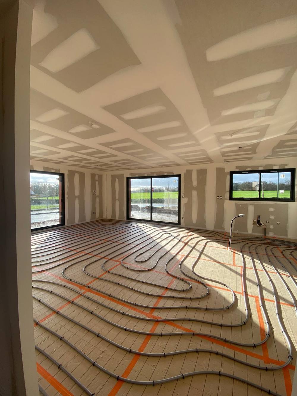 Plancher chauffant posé dans un séjour en construction neuve